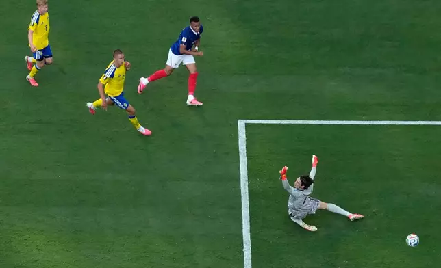 France's Kylian Mbappé (10) scores his team's third goal against Sweden's Jacob Widell Zetterström (1) during a World Cup round of 32 soccer match between France and Sweden in East Rutherford, N.J., near New York, Tuesday, June 30, 2026. (AP Photo/Matt Slocum)
