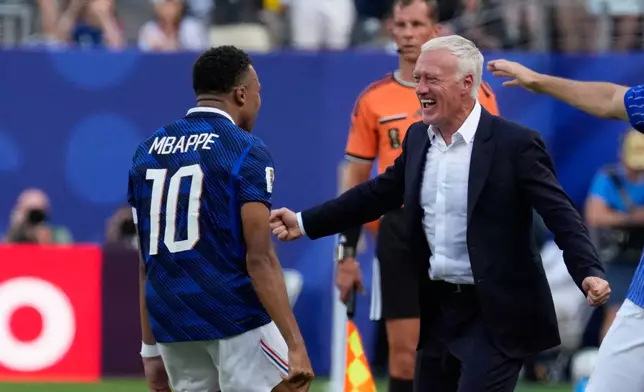 France's Kylian Mbappe, left, celebrates with his coach Didier Deschamps after scoring his side's opening goal during the World Cup round of 32 soccer match between France and Sweden in East Rutherford, N.J., near New York, Tuesday, June 30, 2026. (AP Photo/Seth Wenig)