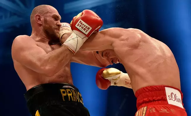 FILE - Ukraine's Wladimir Klitschko, right, and Britain's Tyson Fury, left, exchange blows as Fury wins the world heavyweight title fight for Klitschko's WBA, IBF, WBO and IBO belts in the Esprit Arena in Duesseldorf, western Germany, Saturday, Nov. 28, 2015. (AP Photo/Martin Meissner, File)