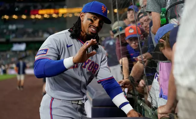 New York Mets' Francisco Lindor waves as he signs autographs for fans before a baseball game against the Milwaukee Brewers, Tuesday, July 21, 2026, in Milwaukee. (AP Photo/Aaron Gash)