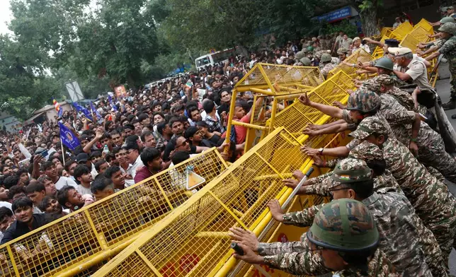 Supporters of the Cockroach Janta Party push against a barricade as they attempt to march to India's Parliament, demanding the resignation of the education minister, in New Delhi, Monday, July 20, 2026. (AP Photo/Shekhar Yadav)