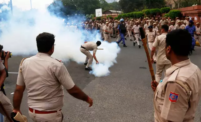 Security officers use tear gas shell to disperse supporters of the Cockroach Janta Party as they attempt to march to India's Parliament, demanding the resignation of the education minister, in New Delhi, Monday, July 20, 2026. (AP Photo/Shekhar Yadav)