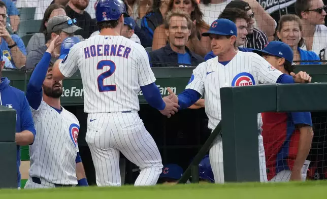 Chicago Cubs' Nico Hoerner (2) is greeted by manager Craig Counsell, right, after scoring against the Detroit Tigers during the first inning of a baseball game Tuesday, July 21, 2026, in Chicago. (AP Photo/David Banks)