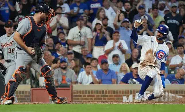 Chicago Cubs' Dansby Swanson, right, is safe at home plate as Detroit Tigers catcher Jake Rogers, left takes a late throw during the third inning of a baseball game Tuesday, July 21, 2026, in Chicago. (AP Photo/David Banks)