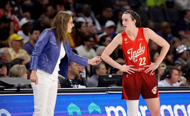 Indiana Fever head coach Stephanie White talks with Indiana Fever guard Caitlin Clark (22) during the first half of an WNBA basketball game against the Las Vegas Aces Sunday, July 12, 2026, in Las Vegas. (Steve Marcus/Las Vegas Sun via AP)