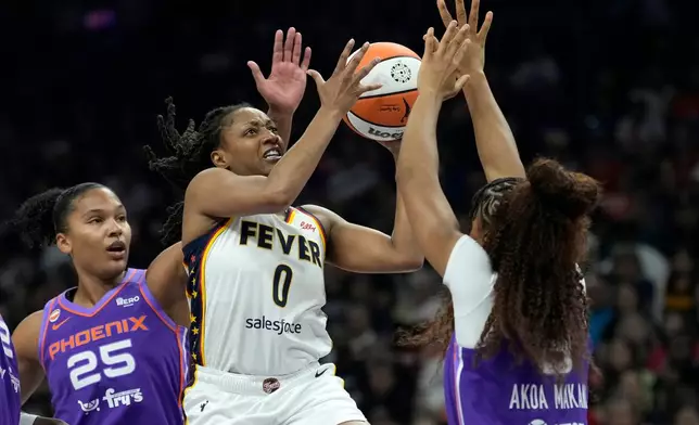 Indiana Fever guard Kelsey Mitchell (0) drives between Phoenix Mercury forward Alyssa Thomas (25) and Mercury guard Monique Akoa Makani, right, during the first half of a WNBA basketball game, Thursday, July 9, 2026, in Phoenix. (AP Photo/Ross D. Franklin)