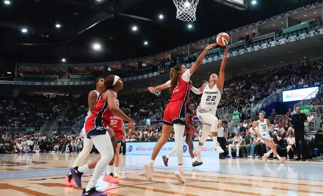 Toronto Tempo's Julie Altmand (22) shoots on Washington Mystics' Lauren Betts, center, during the first half of a WNBA basketball game in Toronto, Tuesday, July 14, 2026. (Chris Young/The Canadian Press via AP)