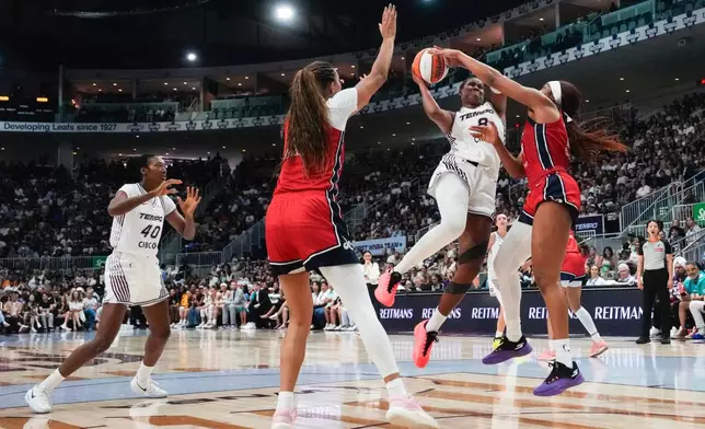 Toronto Tempo's Nyara Sabally, center, drives as Washington Mystics' Cotie McMahon, right, defends during the first half of a WNBA basketball game in Toronto, Tuesday, July 14, 2026. (Chris Young/The Canadian Press via AP)