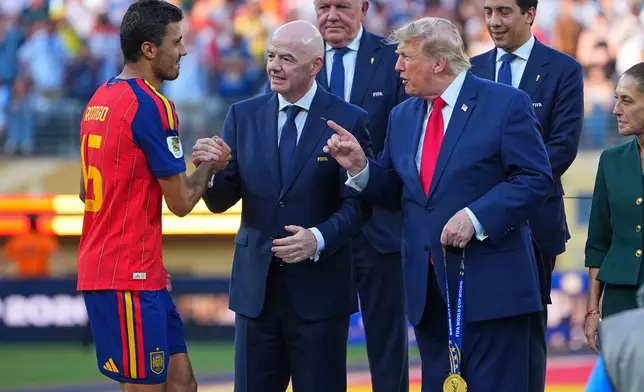 Spain's Rodri (16) is greeted by FIFA President Gianni Infantino and President Donald J. Trump during the presentation ceremony after the World Cup final soccer match between Spain and Argentina in East Rutherford, N.J., near New York, Sunday, July 19, 2026. (AP Photo/Julio Cortez)