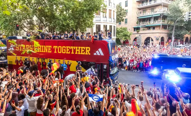 Players from Spain's national soccer team celebrate atop a bus as it travels through crowded streets in Madrid, Monday, July 20, 2026, after Spain defeated Argentina in the World Cup final in East Rutherford, N.J., near New York. (César Vallejo/Europa Press via AP)