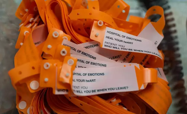 Neon-orange patient wristbands for visitors are displayed during the "Hospital of Emotions" exhibition inside a former hospital building in Los Angeles, Wednesday, July 22, 2026. (AP Photo/Jae C. Hong)