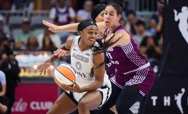 Las Vegas Aces' Jackie Young (0) drives past Toronto Tempo's Kia Nurse (11) during the first half of a WNBA basketball game in Toronto, on Monday, July 20, 2026. (Sammy Kogan/The Canadian Press via AP)