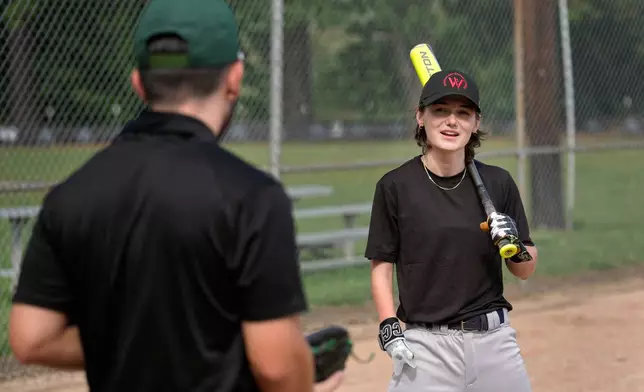 Brittany Apgar, right, who was born without a right hand, talks with Logan Vacharasin, left, before batting practice at a field in Greensboro, N.C., Wednesday, July 22, 2026 before joining the Los Angeles team in the Women's Pro Baseball League. (AP Photo/Chuck Burton)