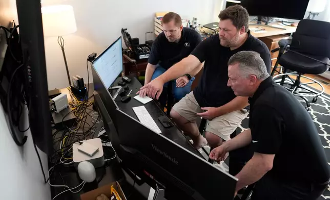 Andrew Leeper, left, Will Minkoff and Tom Johnstone, right, of Nashville Severe Weather, look over weather data Monday, April 20, 2026, in Nashville, Tenn. (AP Photo/George Walker IV)