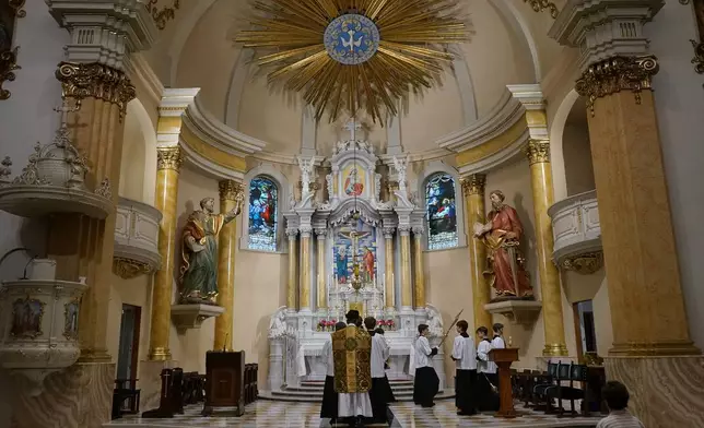The Rev. John Ubel, pastor of the Church of Saint Agnes, processes into the sanctuary with altar servers at the start of one of the Catholic parish’s Latin Masses in St. Paul, Minn., Sunday, June 28, 2026. (AP Photo/Giovanna Dell’Orto)