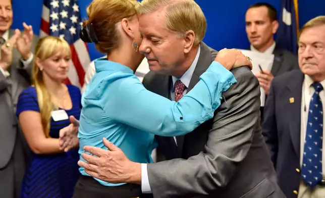 FILE - Republican presidential candidate, Sen. Lindsey Graham, R-S.C., right, hugs his sister Darline Graham after filing for the South Carolina presidential primary, Sept. 1, 2015, at the GOP headquarters in Columbia, S.C. (AP Photo/Richard Shiro, File)