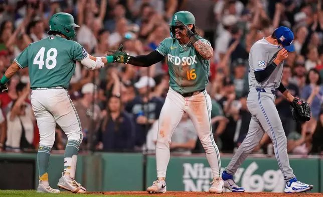 Toronto Blue Jays pitcher CJ Van Eyk, right, heads back to the mound as Boston Red Sox's Jarren Duran, center, is congratulated by Anthony Seigler (48) after scoring on a double, during the eighth inning of a baseball game, Friday, July 24, 2026, in Boston. (AP Photo/Charles Krupa)