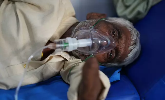A patient receiving oxygen lies on a hospital bed while suffering from a heat-related illness amid high temperatures during a heat wave in Banda, northern Indian state of Utter Pradesh, Friday, June 19 , 2026. (AP Photo/Rajesh Kumar Singh)