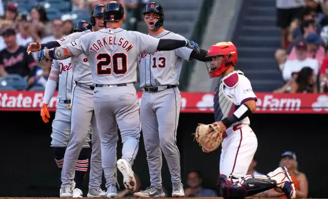 Detroit Tigers' Spencer Torkelson, center, is congratulated by Colt Keith, second from left, and Dillon Dingler, second from right, after hitting a three-run home run as Los Angeles Angels catcher Logan O'Hoppe, ring, watches during the first inning of a baseball game Saturday, July 18, 2026, in Anaheim, Calif. (AP Photo/Mark J. Terrill)