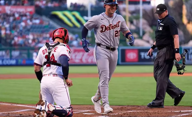 Detroit Tigers' Spencer Torkelson, center, scores after hitting a three-run home run as Los Angeles Angels catcher Logan O'Hoppe, left, and home plate umpire Ryan Wills watch during the first inning of a baseball game Saturday, July 18, 2026, in Anaheim, Calif. (AP Photo/Mark J. Terrill)