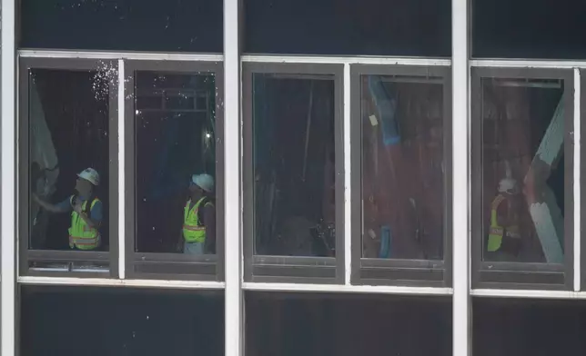 People inspect buckled support beams inside 235 East 42nd Street, Wednesday, July 8, 2026, in New York. (AP Photo/Yuki Iwamura)
