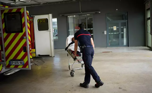 Paramedics take a patient to the emergency department of the Paris-Saclay Hospital, outside Paris, Tuesday June 30, 2026. (AP Photo/Christophe Ena )