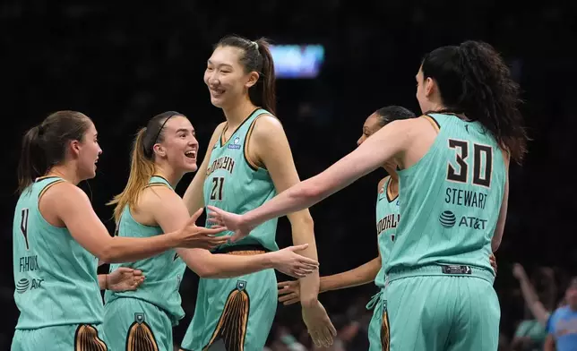 New York Liberty's Han Xu (21) celebrates with teammates Sabrina Ionescu, Breanna Stewart (30) and Marine Fauthoux (4) after scoring during the second half of a WNBA basketball game against the Chicago Sky Wednesday, July 22, 2026, in New York. (AP Photo/Frank Franklin II)