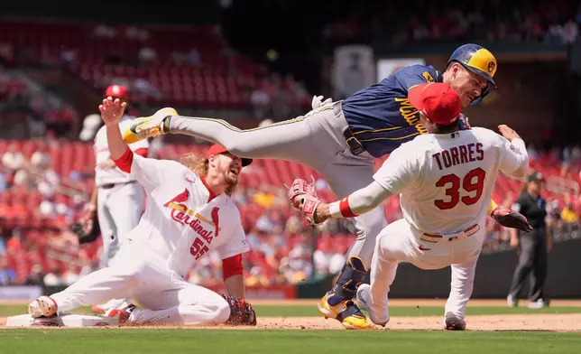 Milwaukee Brewers' Joey Ortiz is safe at first for a single as he collides with St. Louis Cardinals second baseman Bryan Torres (39) and pitcher Ryne Stanek (55) as they cover first base during the seventh inning in the first game of a baseball doubleheader Tuesday, July 7, 2026, in St. Louis. (AP Photo/Jeff Roberson)
