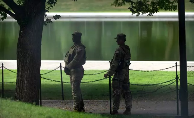 National Guard members stand near the Lincoln Memorial Reflecting Pool, Friday, July 10, 2026, in Washington. (AP Photo/Mark Schiefelbein)