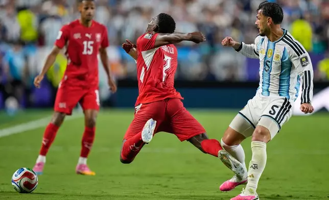 Switzerland's Breel Embolo (7) reacts as he dives in a challenge from Argentina's Leandro Paredes (5) for which he got a second yellow card during the World Cup quarterfinal soccer match between Argentina and Switzerland in Kansas City, Mo., Saturday, July 11, 2026. (AP Photo/Ashley Landis)