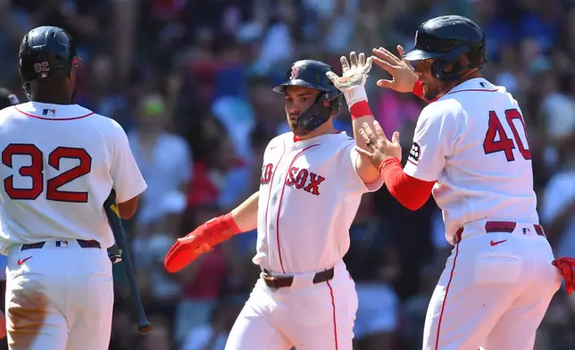 Boston Red Sox's Caleb Durbin, center, celebrates with Andruw Monasterio (32) and Willson Contreras (40) after he and Contreras scored on a two-run single by Jarren Duran in the fourth inning of a baseball game against the Toronto Blue Jays, Sunday, July 26, 2026, in Boston. (AP Photo/Steven Senne)