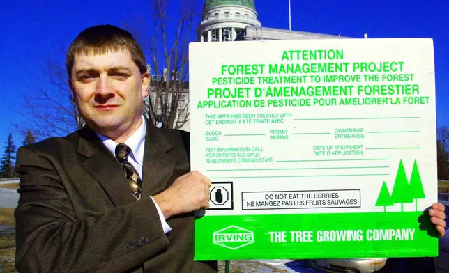 FILE - Rep. Troy Jackson, D-Fort Kent, holds up a poster warning people not to eat berries from sprayed areas treated by paper companies, outside the State House, in Augusta, Maine, Wednesday, Jan. 28, 2004. (AP Photo/Pat Wellenbach,File)