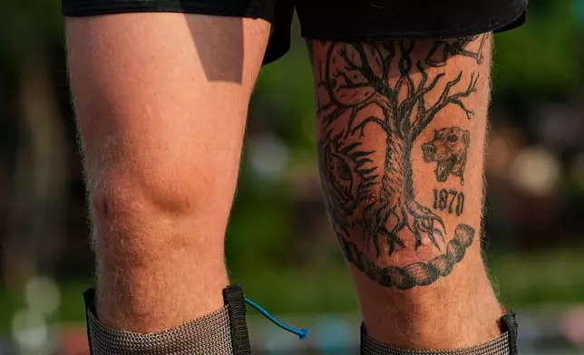 Tristan Vanbeek, of Tennessee, shows his tattoos while competing during the Lumberjack World Championships, Saturday, July 18, 2026, in Hayward, Wis. (AP Photo/Ellen Schmidt)