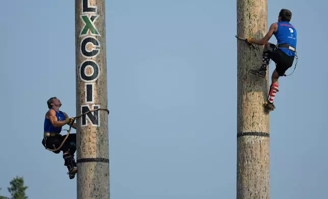 Deven Blair, left, and Cameron Pilgreen compete in the 90-foot climb during the Lumberjack World Championships, Saturday, July 18, 2026, in Hayward, Wis. (AP Photo/Ellen Schmidt)