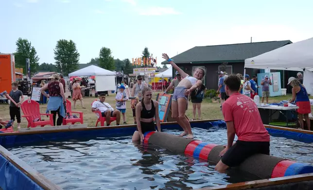 Children practice log rolling with the Namekagon River Rollers, a local school teaching the sport, during the Lumberjack World Championships, Friday, July 17, 2026, in Hayward, Wis. (AP Photo/Ellen Schmidt)