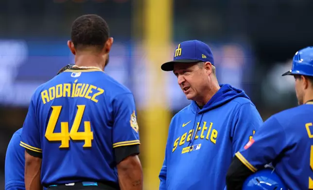 Seattle Mariners manager Dan Wilson exchanges words with Julio Rodríguez after being hit by the ball in the first inning of a baseball game against the Los Angeles Angels, Thursday, July 2, 2026, in Seattle. (AP Photo/Kevin Ng)