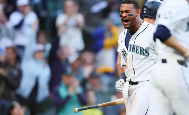 Seattle Mariners' Julio Rodríguez reacts after scoring in the sixth inning of a baseball game against the Los Angeles Angels, Tuesday, June 30, 2026, in Seattle. (AP Photo/Kevin Ng)