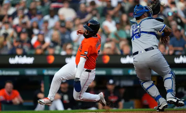 Detroit Tigers' Gleyber Torres, left, runs around Kansas City Royals catcher Salvador Perez (13) to score during the first inning of a baseball game Friday, July 24, 2026, in Detroit. (AP Photo/Paul Sancya)