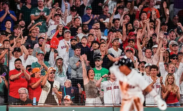 Boston Red Sox fans cheer after an RBI double by Ceddanne Rafaela during the seventh inning of a baseball game against the Baltimore Orioles, Monday, July 20, 2026, in Boston. (AP Photo/Charles Krupa)