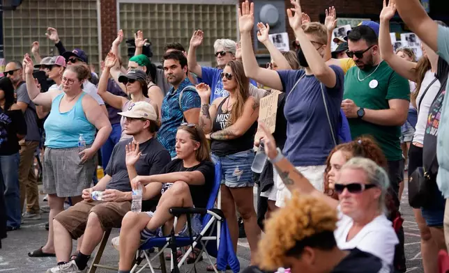 Attendees gesture as they gather at a memorial Thursday, July 23, 2026, in Madison, Wis., where a Madison police officer shot and killed Corey Durell Ruiz on Wednesday. (AP Photo/Kayla Wolf)