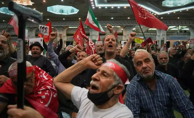 Mourners chant as they raise their fists during a gathering commemorating the late Supreme Leader Ali Khamenei at the Imam Khomeini Mosalla Grand Mosque in Tehran, Iran, Tuesday, July 14, 2026. (AP Photo/Vahid Salemi)