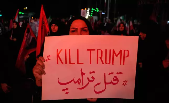 A pro-government demonstrator holds an anti-Trump placard in a gathering commemorating the late Iranian Supreme Leader Ayatollah Ali Khamenei at a square in Tehran, Saturday, July 11, 2026. (AP Photo/Vahid Salemi)
