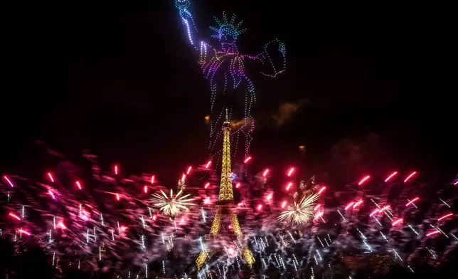 Fireworks and drones illuminate the Eiffel Tower in Paris, during the eve of Bastille Day celebrations late Monday, July 13, 2026. (AP Photo/Thomas Padilla)