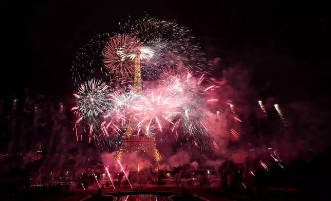 Fireworks and drones illuminate the Eiffel Tower in Paris, during the eve of Bastille Day celebrations, Monday, July 13, 2026. (AP Photo/Thomas Padilla)