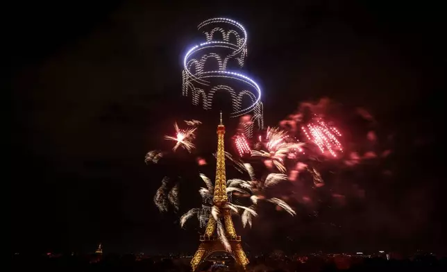 Fireworks and drones illuminate the Eiffel Tower in Paris, during the eve of Bastille Day celebrations late Monday, July 13, 2026. (AP Photo/Thomas Padilla)