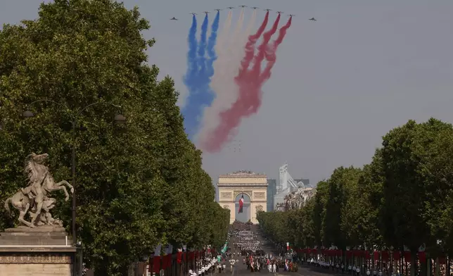 Jets from the acrobatic Patrouille de France fly during the Bastille Day military parade on the Champs-Elysees avenue in Paris, Tuesday, July 14, 2026. (AP Photo/Thomas Padilla)