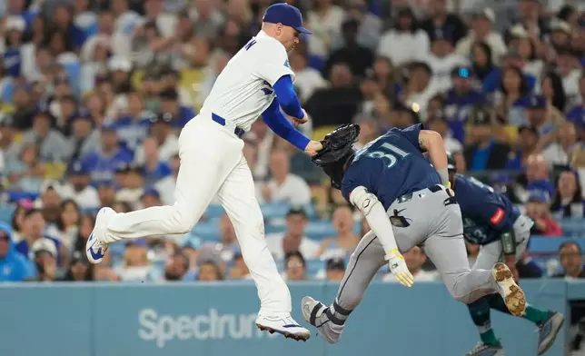 Los Angeles Dodgers first baseman Freddie Freeman, left, tags out Seattle Mariners' Pete Woodworth at first during the sixth inning of a baseball game Thursday, July 30, 2026, in Los Angeles. (AP Photo/Mark J. Terrill)
