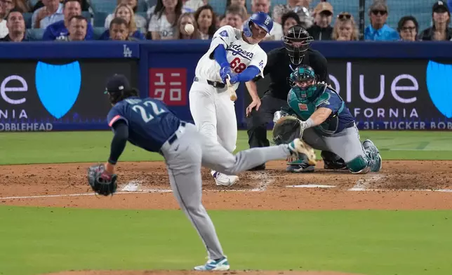 Los Angeles Dodgers' Dalton Rushing, second from left, hits a three-run home run as Seattle Mariners starting pitcher Bryan Woo, left, and catcher Cal Raleigh watch during the fourh inning of a baseball game Thursday, July 30, 2026, in Los Angeles. (AP Photo/Mark J. Terrill)