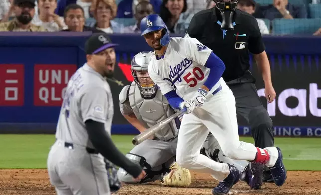 Los Angeles Dodgers' Mookie Betts, right, hits an RBI single as Colorado Rockies pitcher Antonio Senzatela, left, reacts during the eighth inning of a baseball Wednesday, July 8, 2026, in Los Angeles. (AP Photo/Mark J. Terrill)