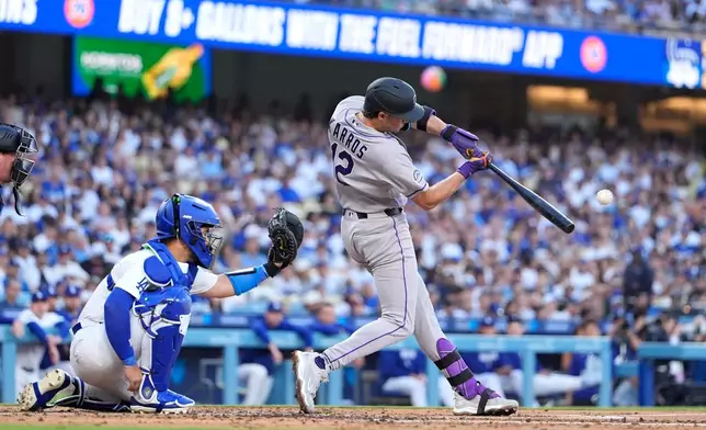 Colorado Rockies' Kyle Karros, right, hits a solo home run as Los Angeles Dodgers catcher Eliezer Alfonzo watches during the second inning of a baseball game Wednesday, July 8, 2026, in Los Angeles. (AP Photo/Mark J. Terrill)